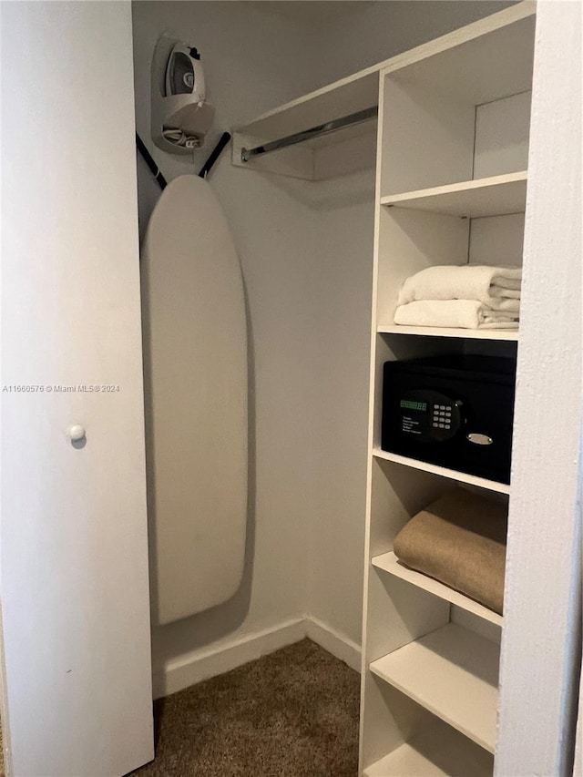 spacious closet featuring dark colored carpet