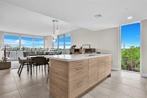 kitchen with light tile patterned flooring, decorative light fixtures, plenty of natural light, and a center island