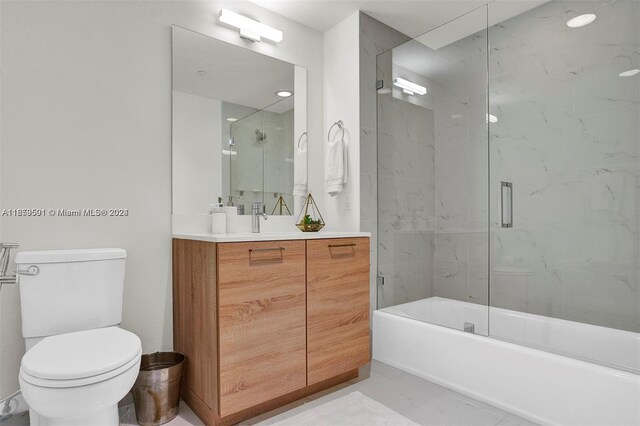 full bathroom with enclosed tub / shower combo, vanity, and toilet