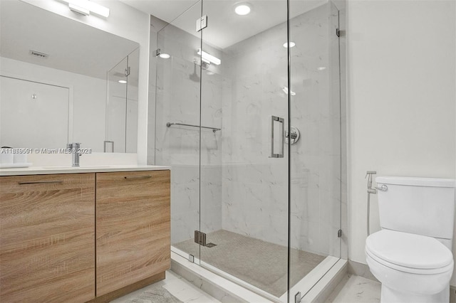 bathroom with a shower with door, vanity, and toilet