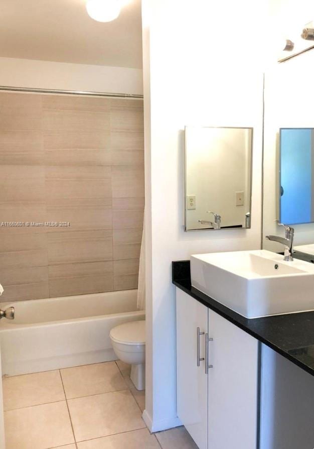 full bathroom featuring tile patterned flooring, vanity, toilet, and shower / bath combination with curtain