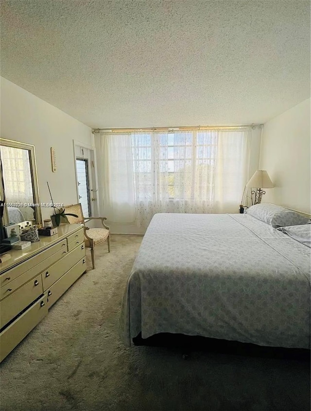 bedroom featuring a textured ceiling and light colored carpet