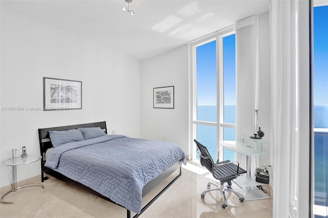 bedroom featuring expansive windows and a water view