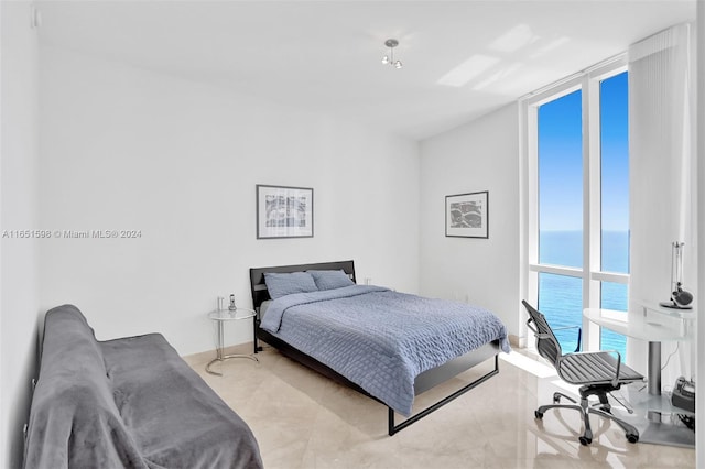 bedroom featuring a water view and floor to ceiling windows