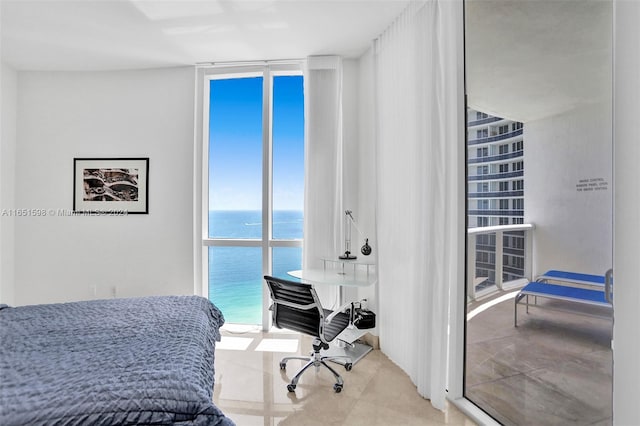 bedroom with a water view and a wall of windows