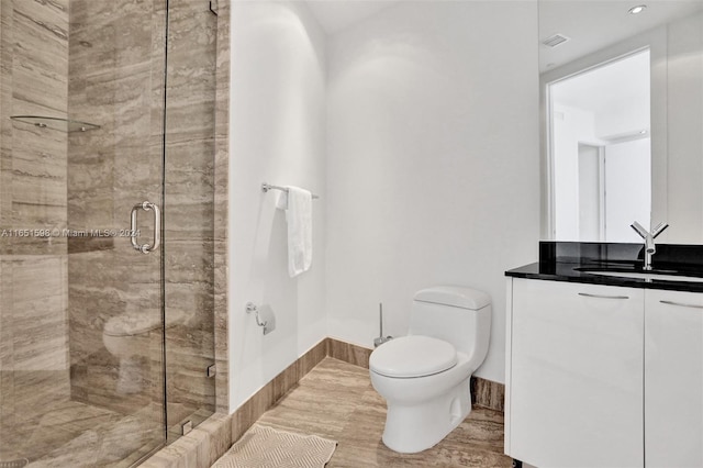 bathroom featuring vanity, toilet, and a shower with door