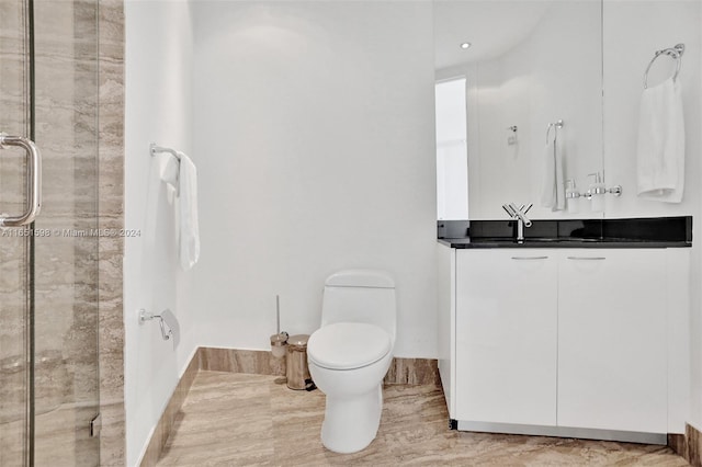 bathroom featuring vanity, toilet, and an enclosed shower