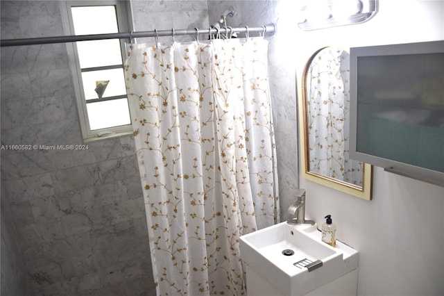 bathroom with walk in shower and sink