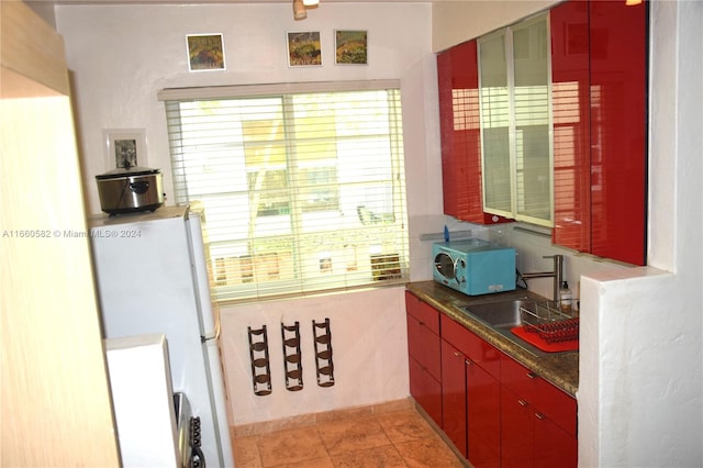 kitchen with white appliances, sink, and light tile patterned floors