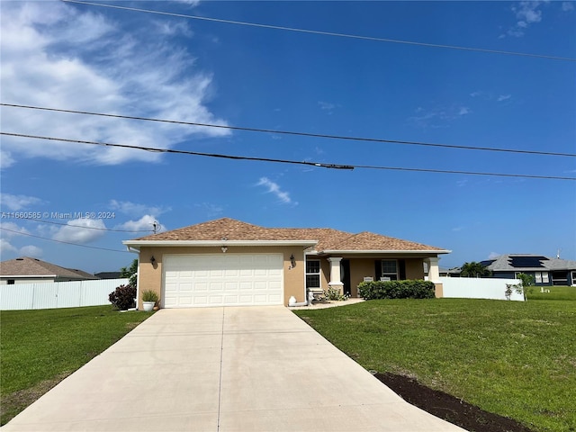 view of front of home with a front yard and a garage