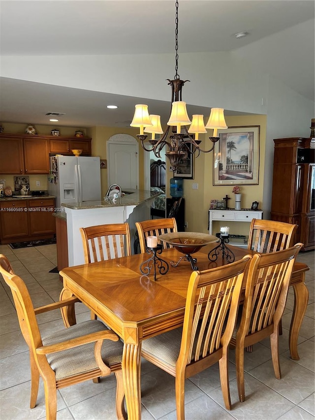 dining space featuring vaulted ceiling, light tile patterned floors, and a chandelier