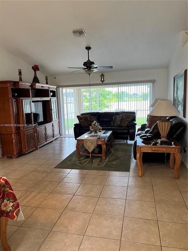 tiled living room with ceiling fan, vaulted ceiling, and a wealth of natural light