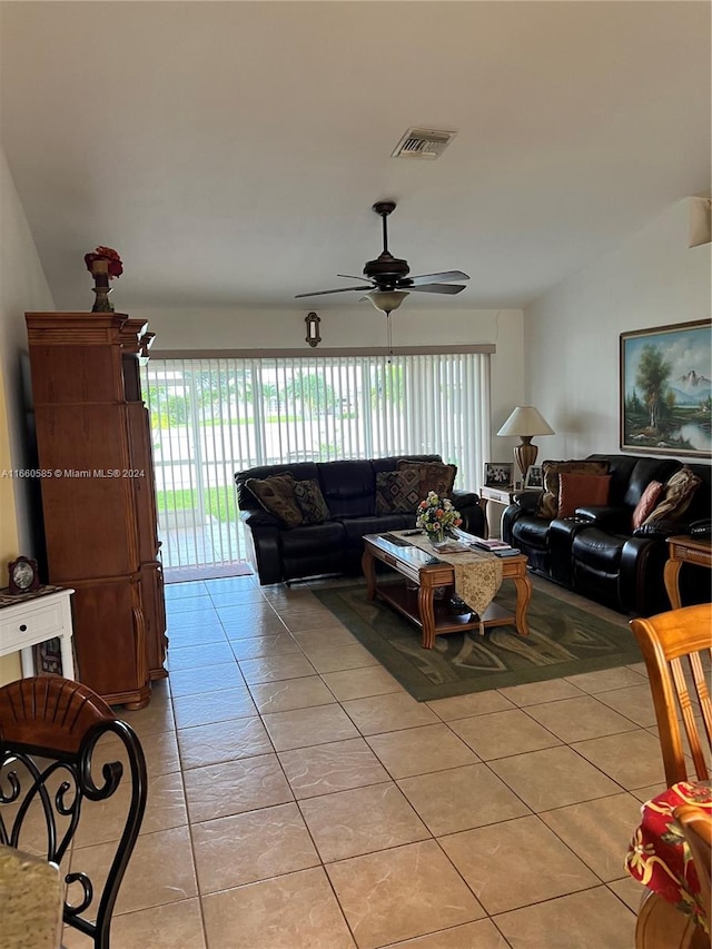 living room with ceiling fan, lofted ceiling, and light tile patterned floors