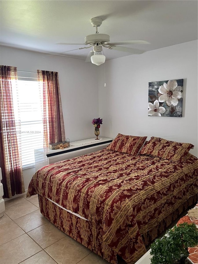 tiled bedroom featuring ceiling fan