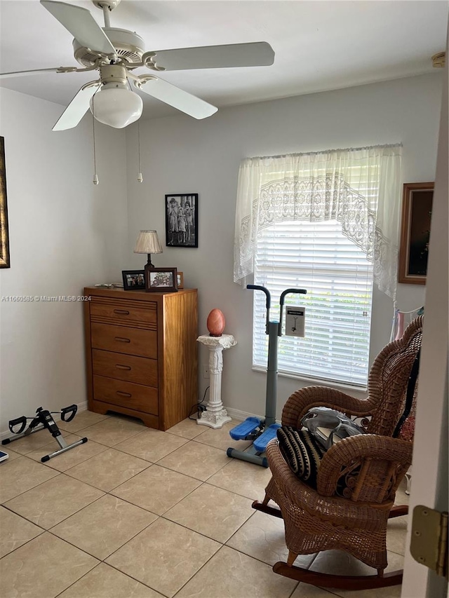 living area with light tile patterned floors and ceiling fan