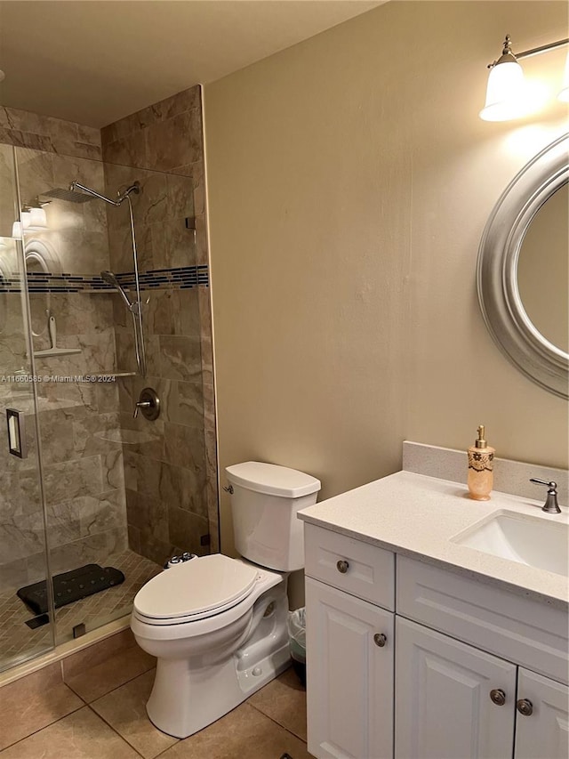 bathroom with vanity, a shower with shower door, toilet, and tile patterned flooring