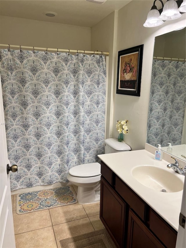 bathroom with tile patterned floors, curtained shower, vanity, and toilet