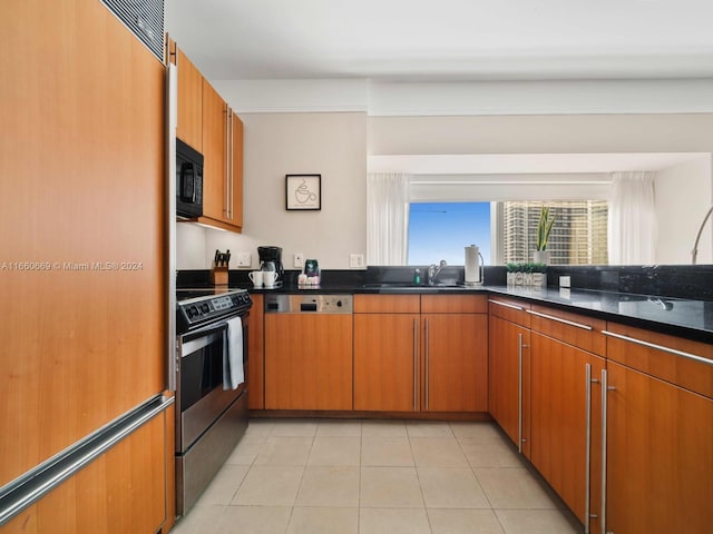1435 Brickell Ave Unit 3212, Miami, FL 33131 - kitchen with light tile patterned flooring, paneled appliances, dark stone countertops, a sink, and brown cabinetry