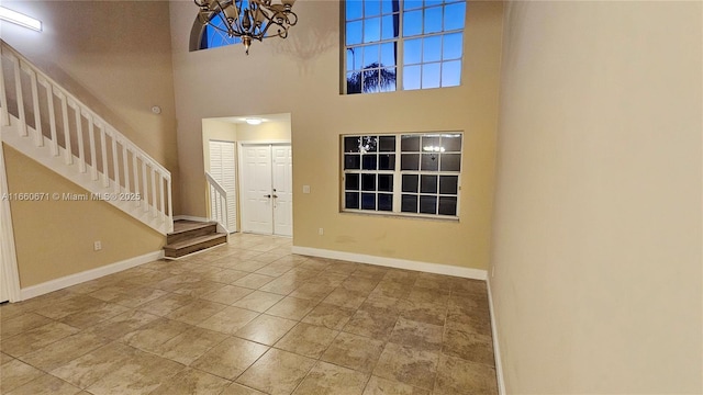 entryway with a notable chandelier, stairway, a high ceiling, and baseboards