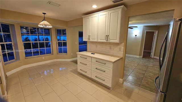 kitchen with white cabinetry, ceiling fan, light tile patterned floors, and stainless steel fridge