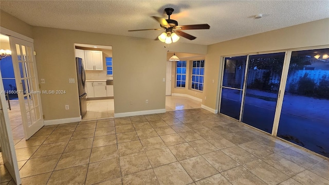 unfurnished room featuring ceiling fan, a textured ceiling, and light tile patterned flooring