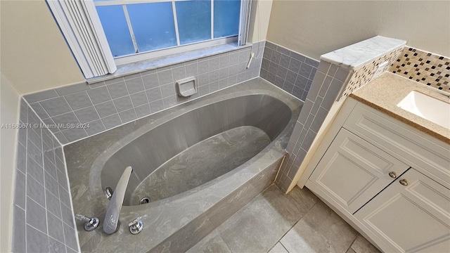 bathroom with a bath, tile patterned flooring, and vanity