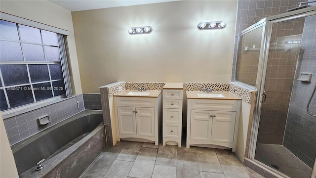 full bath with vanity, a shower stall, and a garden tub