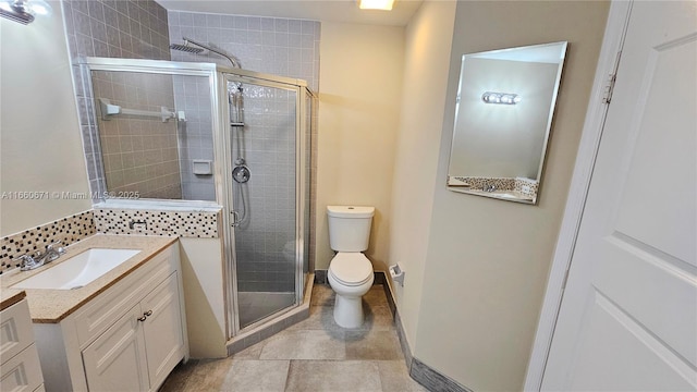 full bath featuring a shower stall, baseboards, toilet, tile patterned floors, and vanity