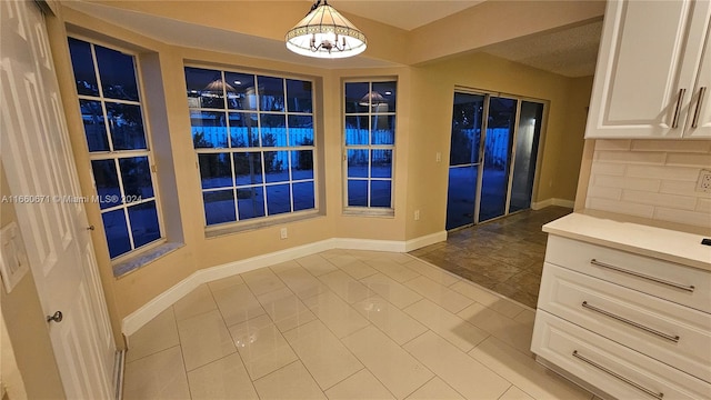 interior space featuring a notable chandelier and light tile patterned floors