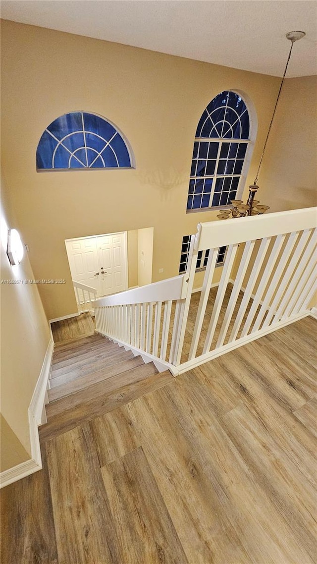 stairway featuring baseboards and wood finished floors