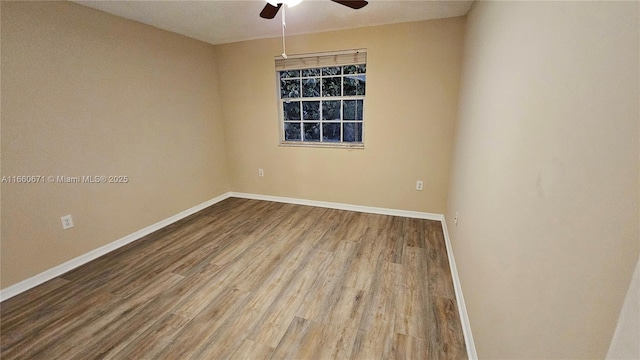 empty room featuring wood finished floors, baseboards, and ceiling fan