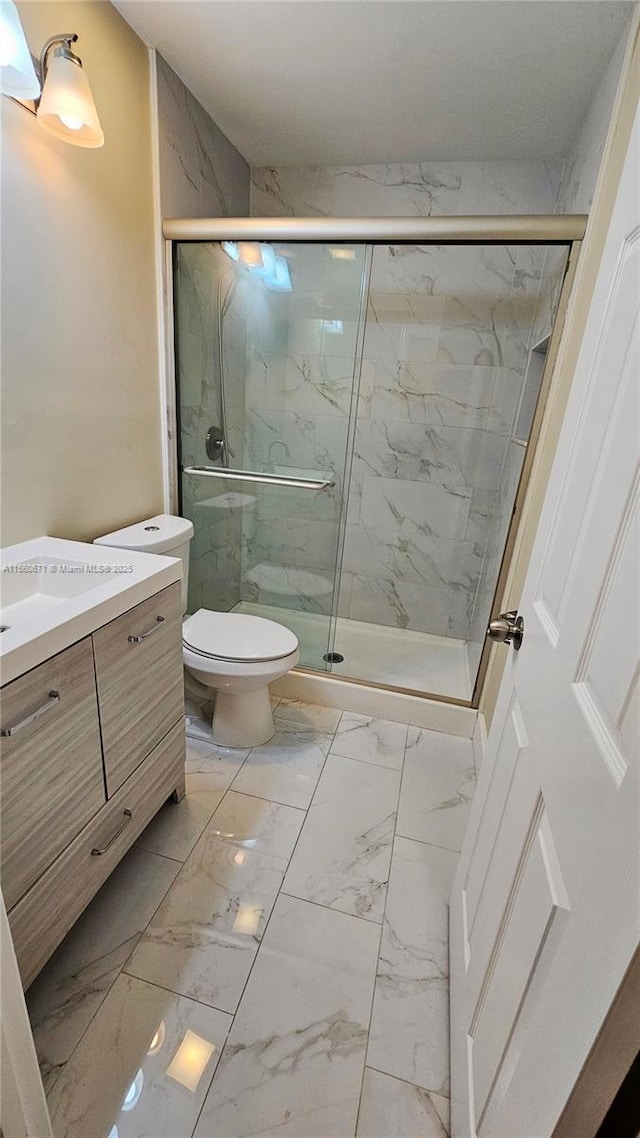 bathroom with a marble finish shower, marble finish floor, and vanity