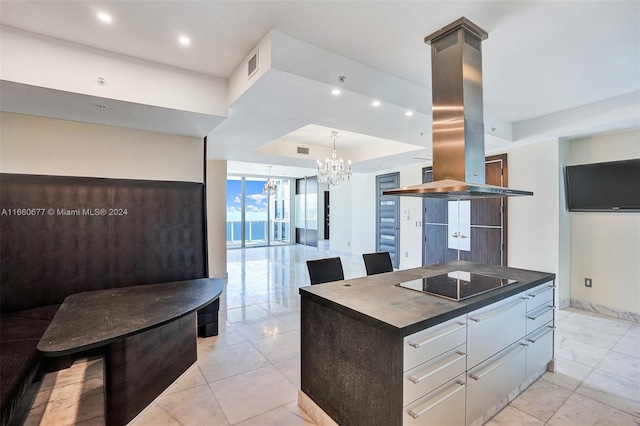 kitchen with a notable chandelier, island exhaust hood, a center island, white cabinetry, and black electric stovetop