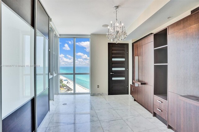 bedroom with a water view, floor to ceiling windows, and a chandelier