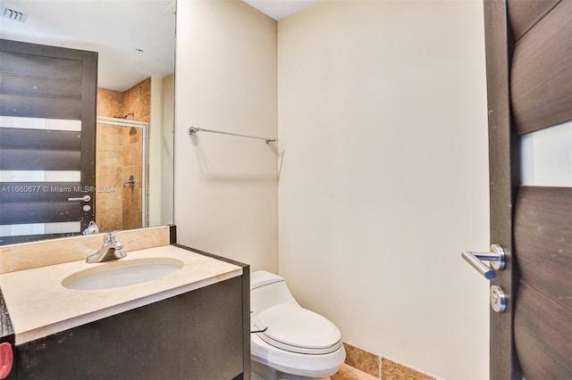 bathroom featuring vanity, toilet, and a shower with shower door