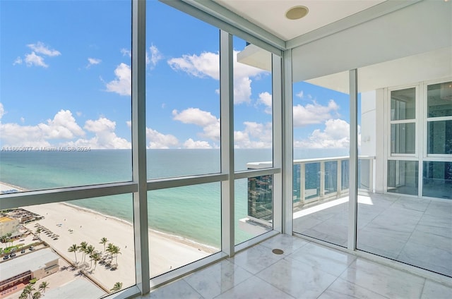 unfurnished sunroom with a beach view and a water view