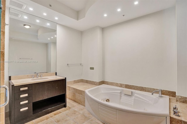 bathroom with tiled tub and vanity