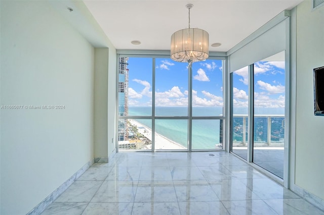 spare room with expansive windows and an inviting chandelier