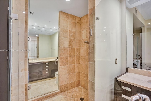 bathroom with vanity, toilet, a shower with shower door, and tile patterned floors