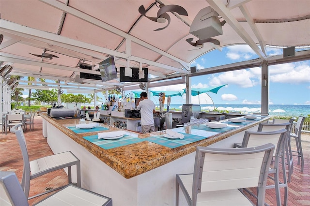 view of patio with ceiling fan and an outdoor bar