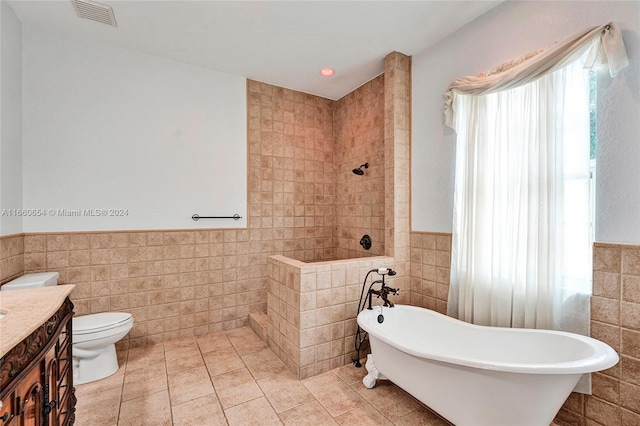 full bathroom with tile patterned flooring, toilet, vanity, independent shower and bath, and tile walls