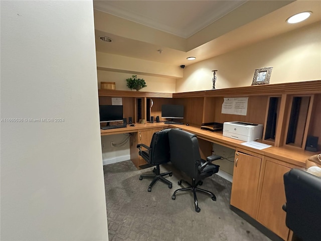 carpeted office space with built in desk