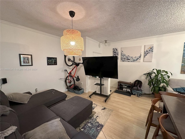 living room with a textured ceiling, crown molding, and hardwood / wood-style flooring