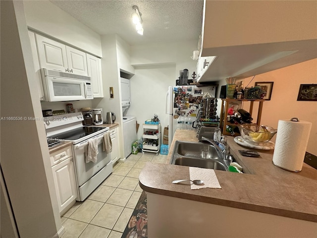 kitchen featuring a textured ceiling, sink, white cabinetry, stacked washing maching and dryer, and white appliances