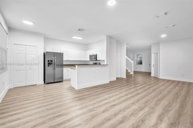 kitchen with white cabinets, stainless steel appliances, and light wood-type flooring