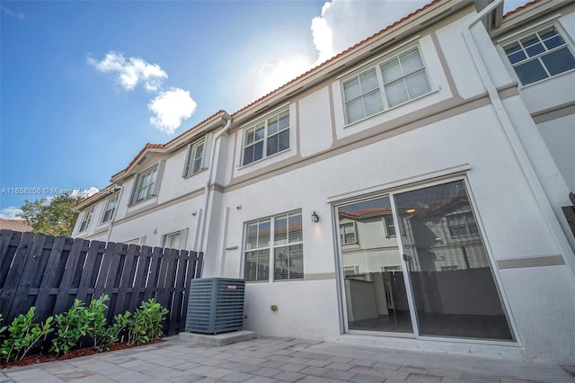 rear view of house featuring central air condition unit and a patio area