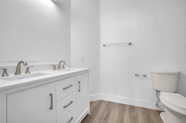 bathroom with hardwood / wood-style floors, vanity, and toilet