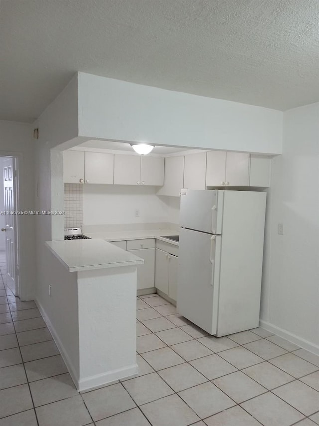 1230 W 54th St Unit 216A, Hialeah, FL 33012 - kitchen with freestanding refrigerator, light tile patterned floors, white cabinetry, light countertops, and a textured ceiling