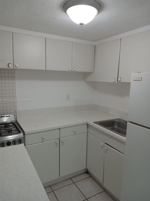 1230 W 54th St Unit 216A, Hialeah, FL 33012 - kitchen featuring white appliances, a textured ceiling, light countertops, and light tile patterned flooring