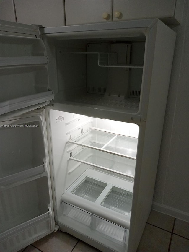 room details featuring tile patterned flooring and refrigerator